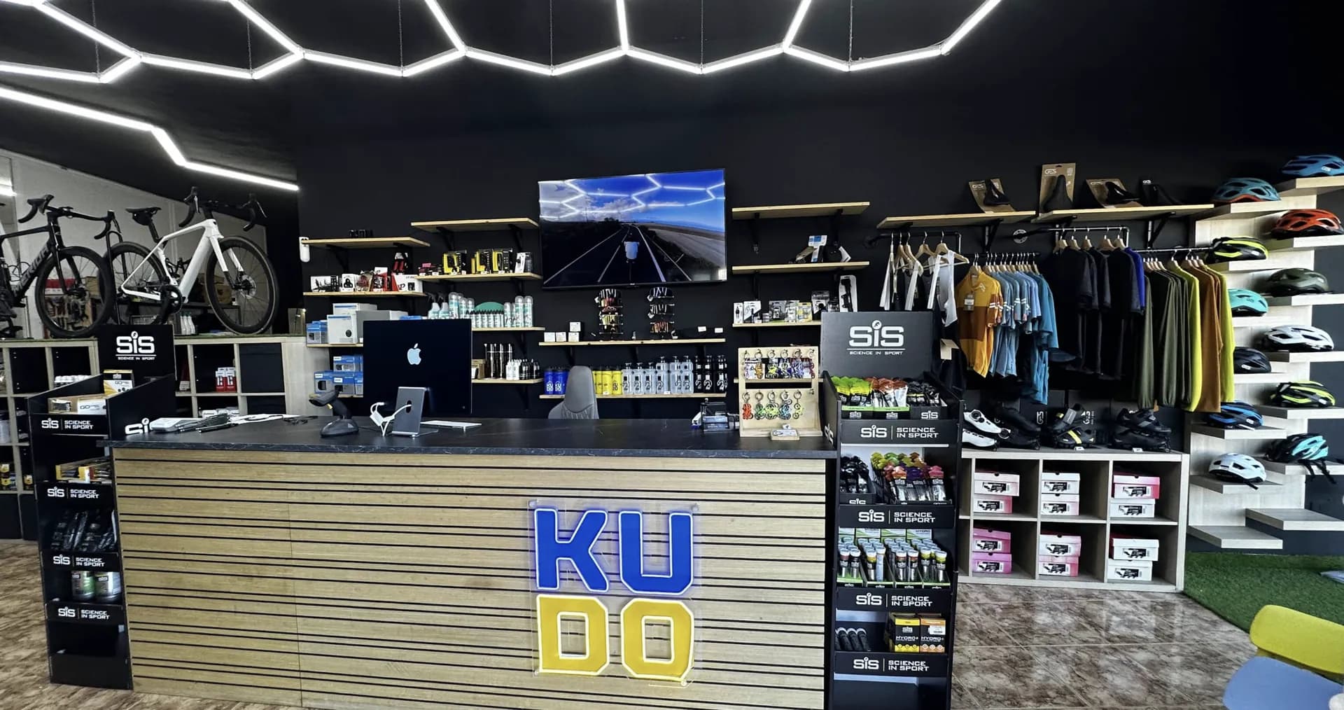 Inside the KUDO Rent office in Puerto de Santiago, Tenerife: the counter, road bikes, helmets and cycling clothing